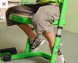 Špatné sezení – nohy zaháknuté za židličku